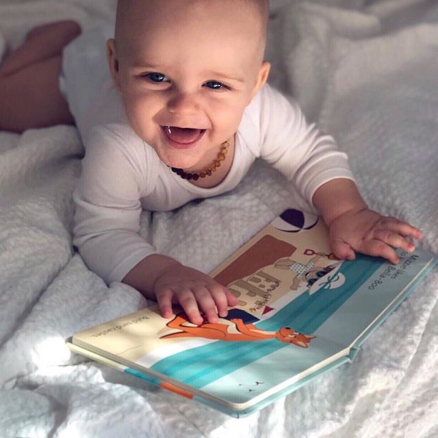 Happy baby reading "at the beach" touch and feel book